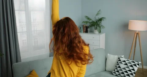 Joyful Caucasian young red-haired woman in yellow sweater dancing and having fun Stock Footage 130157894