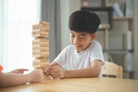 Joyful Child Engaged in Stack Game with Wooden Blocks at Home, Fostering Cr.. Stock Photos