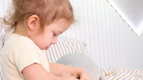 Joyful child exploring creativity in a cozy, sunlit playroom setting 스톡 동영상 295349775