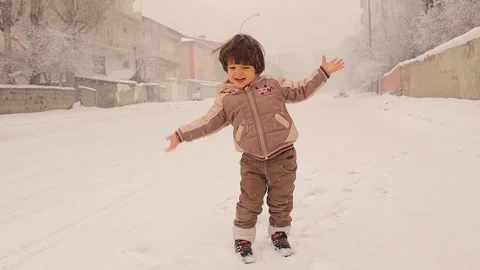 Joyful Child Exploring the Magic of Falling Snowflakes Video stock 295766303