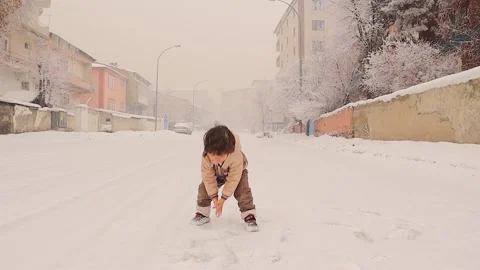 Joyful Child Exploring the Magic of Falling Snowflakes Stock Footage 295768864