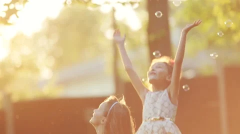 Joyful children having fun with soap bubbles in the garden in a bright sunshine Video stock 67474664