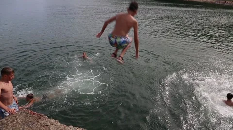 Joyful children jumping and diving into the sea from the old dock Stock Footage 53312931