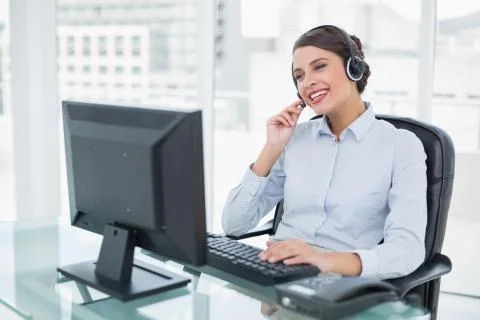 Joyful classy brown haired operator answering a call Stock Photos