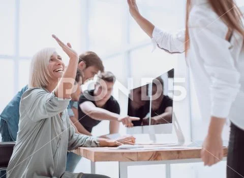 Joyful colleagues giving each other a high five Stock Photos
