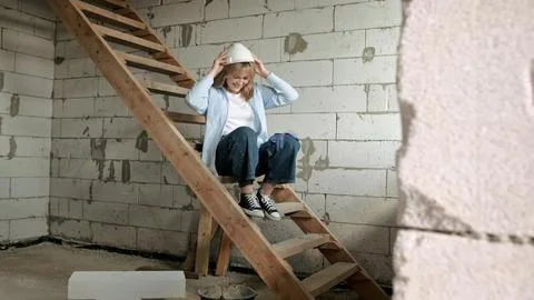 Joyful construction worker preparing for work in unfinished residential house Stock Photos