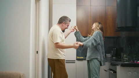 Joyful couple dancing and having fun together in the kitchen Stock Footage 340931936