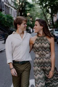 Joyful Couple Holding Hands While Walking Together in an Urban Setting, Enjoying Stock Photos