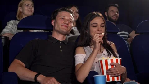 Joyful couple sharing laughter while enjoying a comedy movie at the cinema Видео 311894797