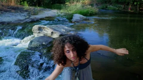 A Joyful Dance by the River: Capturing the Essence of Movement and Nature in a Stock Footage 315734233