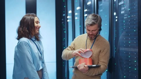 Joyful data specialist opens a present from his girlfriend colleague admiring 動画素材 125759177