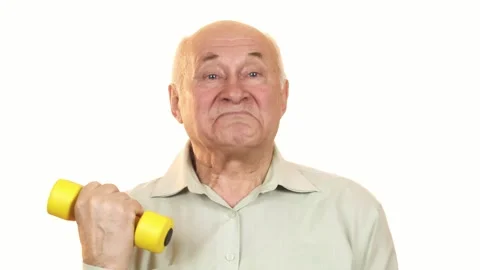 Joyful elderly man giving a thumbs up while lifting a yellow dumbbell Stock Footage 311945923