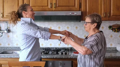 Joyful elderly mother and her adult daughter dancing and laughing together Stock Footage 344397070