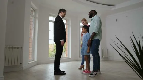 Joyful family taking keys from broker buying house Stock Footage