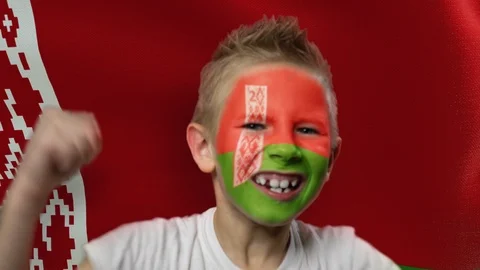 Joyful fan on the background of the flag of Belarus. Happy boy with painted face Stock Footage 124382686