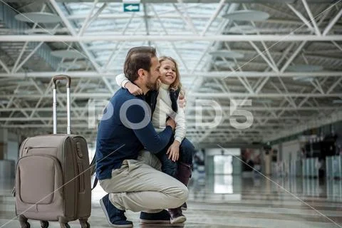 Joyful father and child standing with case in the terminal Stock Photos