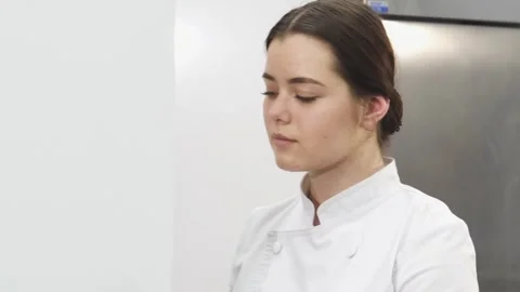 Joyful female chef smiling while preparing ingredients in a bright kitchen Stock Footage 311828083