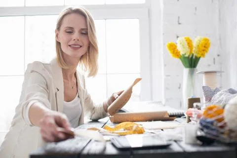 Joyful female dressmaker selecting pattern Stock Photos