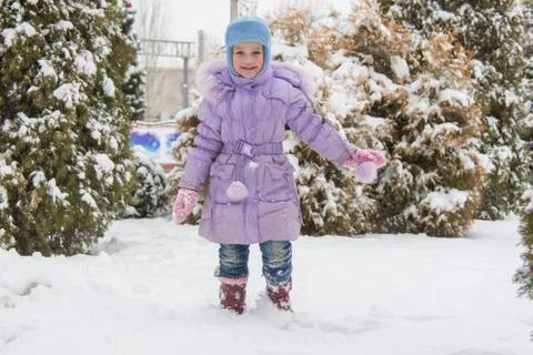 Joyful five years girl goes on snowdrifts Stock Photos