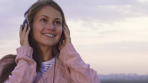 Joyful girl dancing on the rooftop while listening to music with headphones Stock Footage 311944015