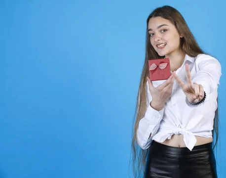 Joyful girl in white shirt demonstrating teeny red gift box, while showing Stock Photos