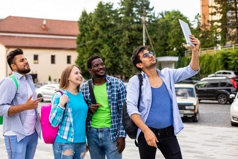 The joyful group of multiethnic students taking a selfie outdoors Stock Photos