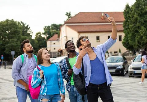 The joyful group of multiethnic students taking a selfie outdoors Stock Photos