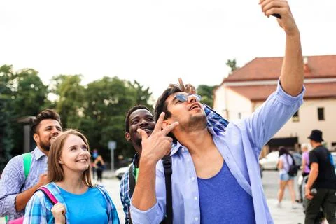 The joyful group of multiethnic students taking a selfie outdoors Stock Photos