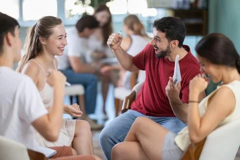 Joyful group of students is sitting in a circle in the classroom Stock Photos