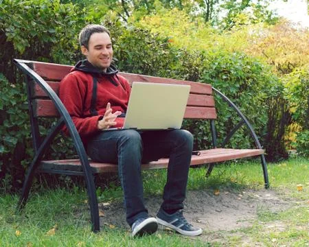 Joyful guy communicates through the Internet on the street. Programmer enjoy  Stock Photos