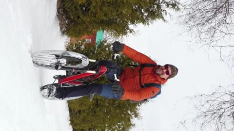 A joyful guy rides a bicycle through freshly fallen snow Stock Footage 263578446