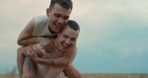 Joyful Handsome Young Guy Jumps out from behind his Boyfriend. Attractive Men Video stock 158405505
