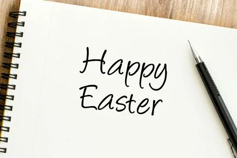 Joyful Happy Easter message handwritten on a clean spiral notebook, next to.. Stock Photos