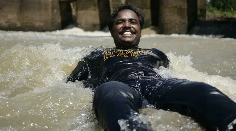 Joyful indian guy lying in water Video stock 59820713