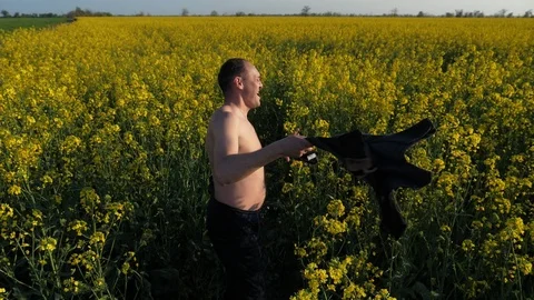 Joyful inspired worker rotating his T-shirt in the hand and then jumping up in 库存影片 107496807