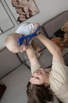 A joyful interaction between a mother and her adorable baby in their cozy living Stock Photos