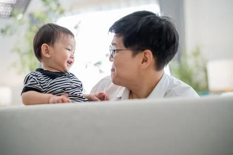 Joyful interaction between a parent and child in a bright indoor space duri.. Stock Photos