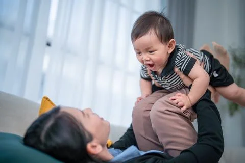 Joyful interaction between parent and baby at home in a playful setting dur.. Stock Photos