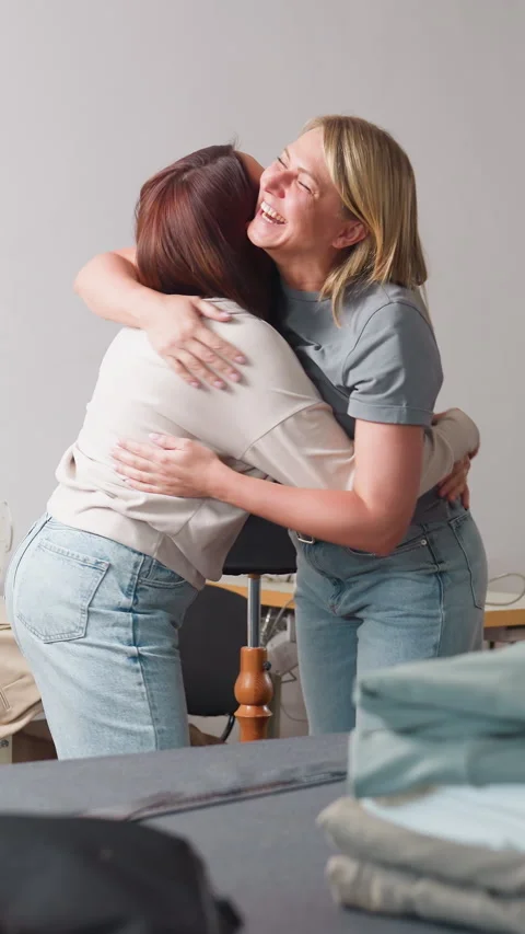 Joyful interaction during clothing fitting in bright studio environment, Two Stock Footage 326935090