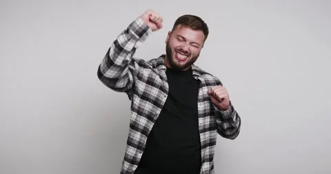 Joyful man dancing and expressing happiness in a playful studio setting wit.. Vídeo Stock 329110458