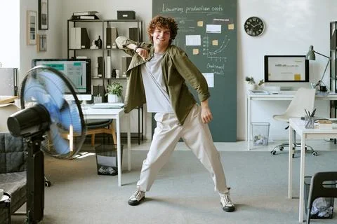Joyful Man Dancing in Front of Fan in Modern Office Stock Photos