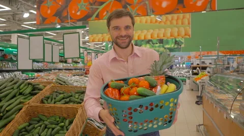 Joyful man holding basket of fresh vegetables Stock Footage 63365771