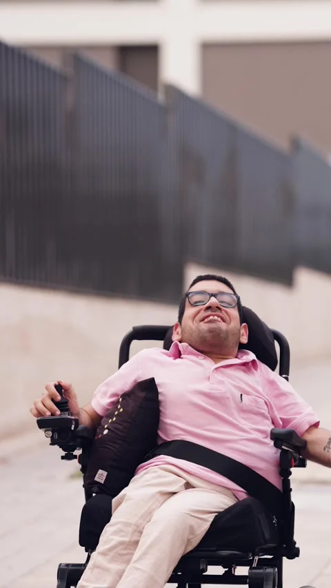 Joyful man with a physical disability laughing in a wheelchair outdoors Stock Footage 341256848
