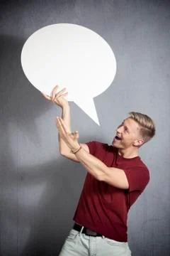 Joyful man presenting white empty speech balloon. Stock Photos