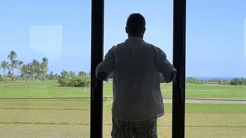 Joyful man standing on the terrace and waving with a shirt, close up, steadycam  Stock-Footage 83677516