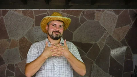 Joyful man in a straw hat on a wall background 4K Stock Footage 115558846