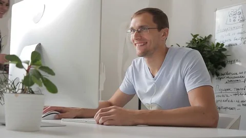 Joyful man works in office at computer and communicates. Stock Footage 81706637