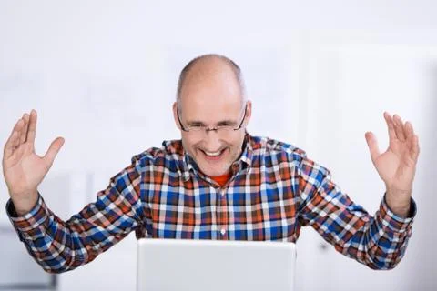 Joyful mature man looking at a laptop screen Stock Photos
