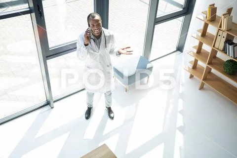 Joyful medical worker standing near window Stock Photos