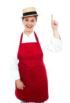 Joyful middle aged cook pointing upwards Stock Photos